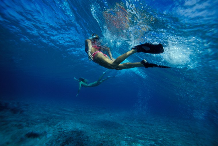Underwater view of lady swimmers- North Shore, Oahu